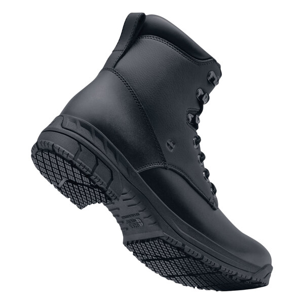 A black Shoes For Crews work boot with a sole.