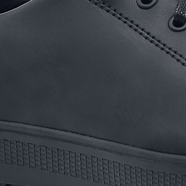 A black leather Shoes For Crews shoe with a rubber sole and toe.