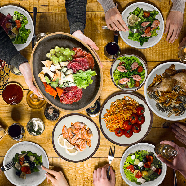 A glazed grey GET ramekin on a table with plates of food.