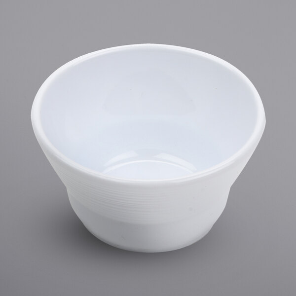 A white Minski melamine fruit bowl with a textured rim on a gray background.