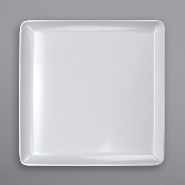 A white square plate on a white surface.