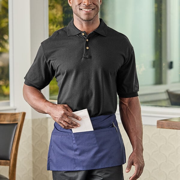 A man wearing a National Patrol black polo shirt and blue pants.