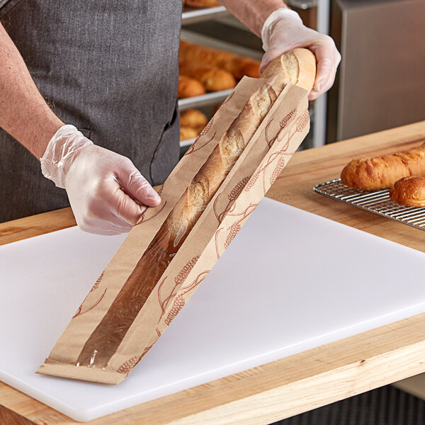 A person holding a Choice kraft paper bread bag with a wheat design window.