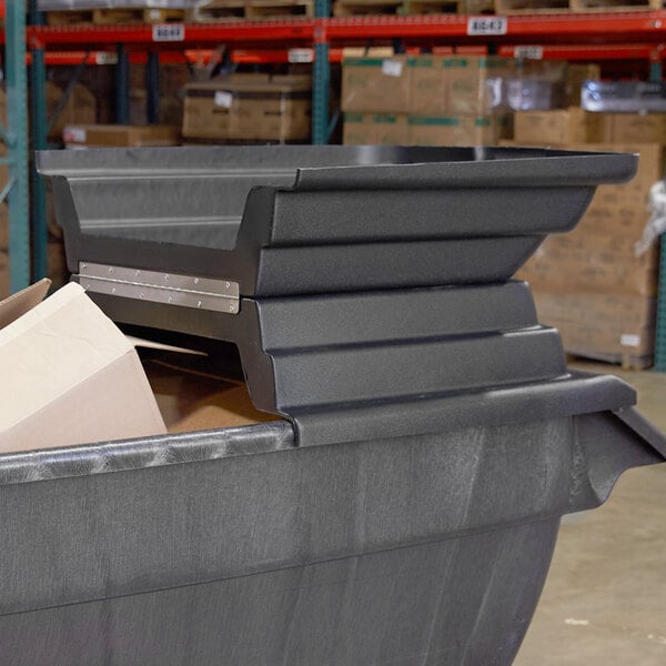 A large black Rubbermaid tilt truck with a hinged dome lid open.