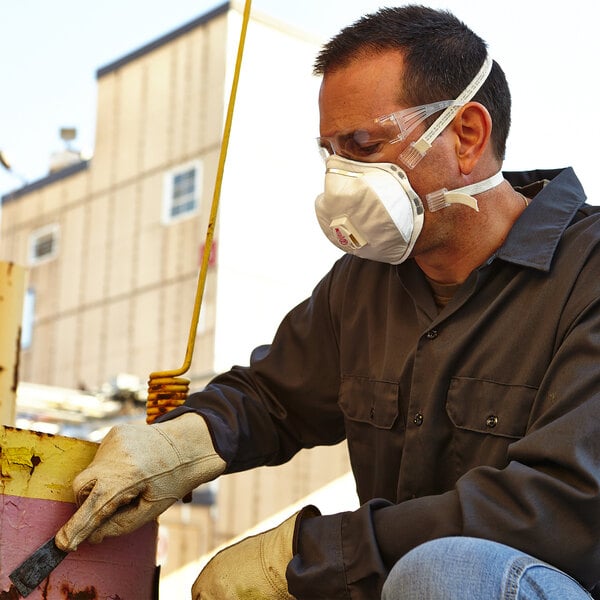 man wearing a respirator while doing construction work