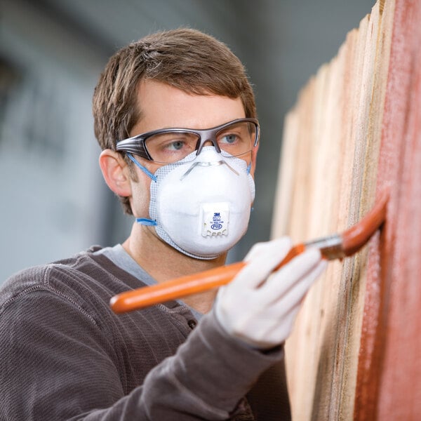man wearing a valve respirator while painting