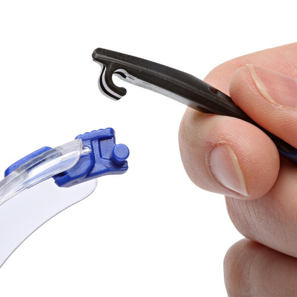 A hand holding 3M Solus safety glasses with blue and black accents and clear lenses.