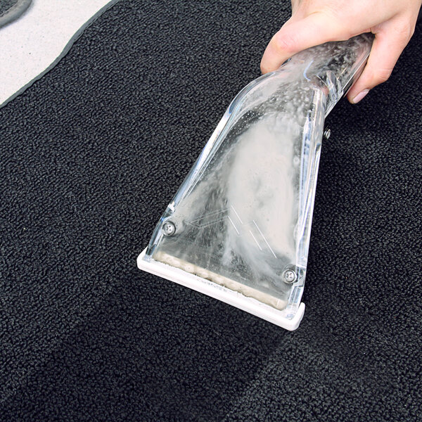A person using a Mytee Air Lite upholstery tool to clean a carpet.