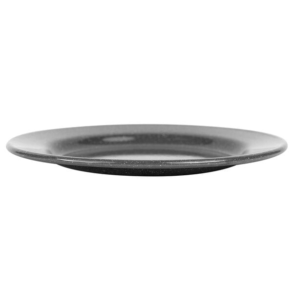 A close up of a black Crow Canyon Home Stinson enamelware salad plate with a speckled surface and wide rim.