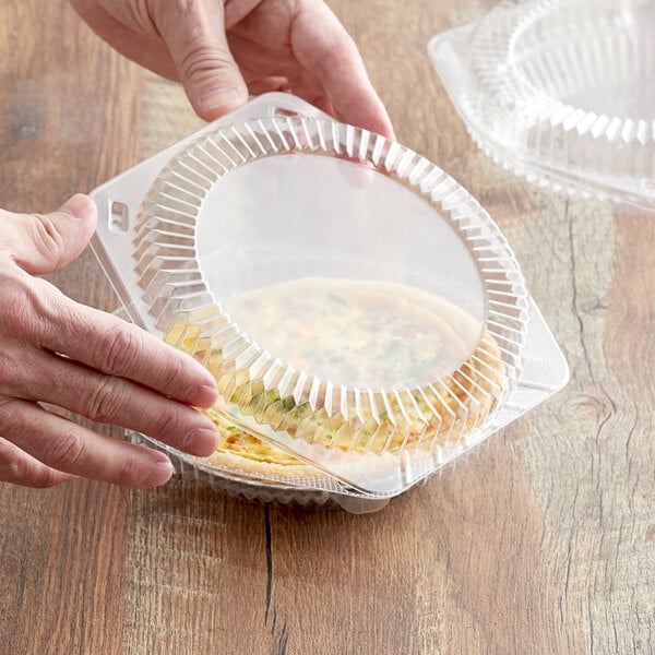 A person holding a Choice clear plastic container with food inside.