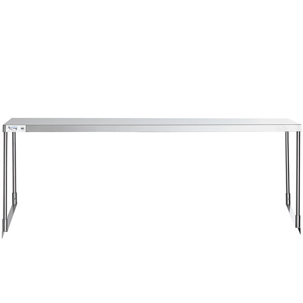 A stainless steel rectangular Avantco single deck overshelf on a white table with metal legs.