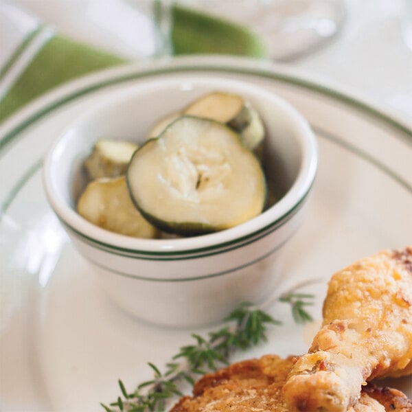 A close-up of a Tuxton bouillon cup with food on a plate.