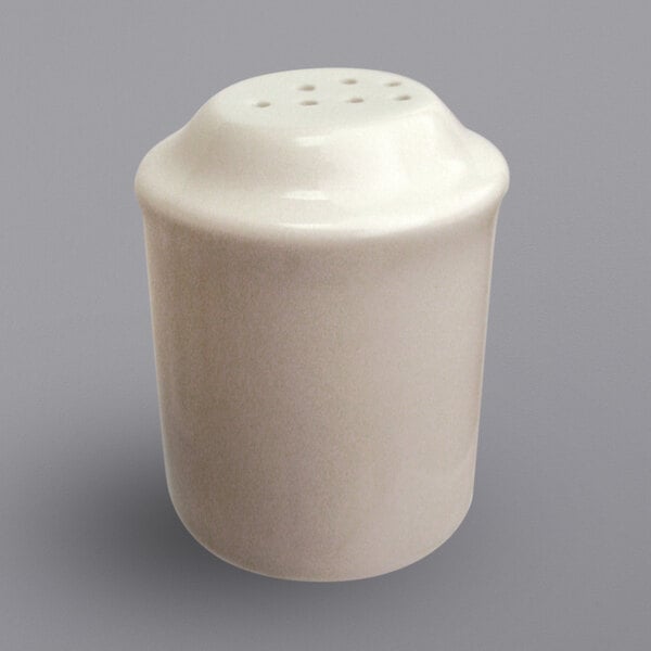 An International Tableware ivory stoneware pepper shaker with holes on top.