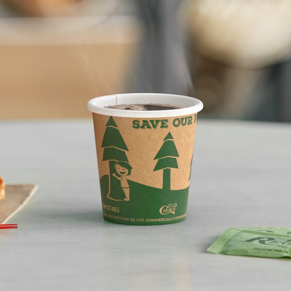 A close-up of a EcoChoice Kraft paper hot cup with a tree print filled with coffee on a table.