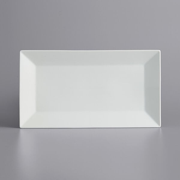 A white rectangular International Tableware porcelain platter on a gray surface.