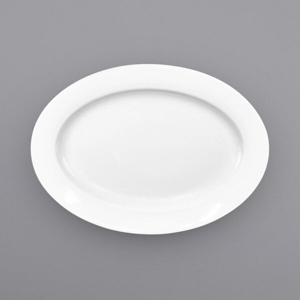 A white International Tableware porcelain platter with a white rim on a gray surface.