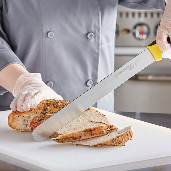 A person using a Dexter-Russell yellow-handled knife to slice meat.