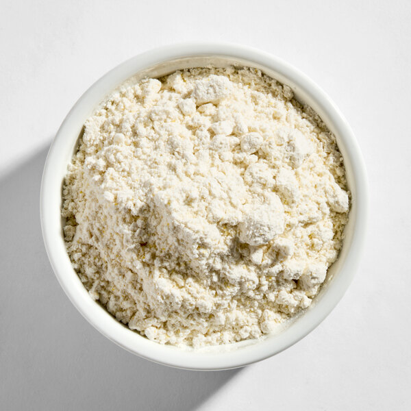 A white bowl filled with a coarse, off-white powder, identified as Belgian waffle base mix.