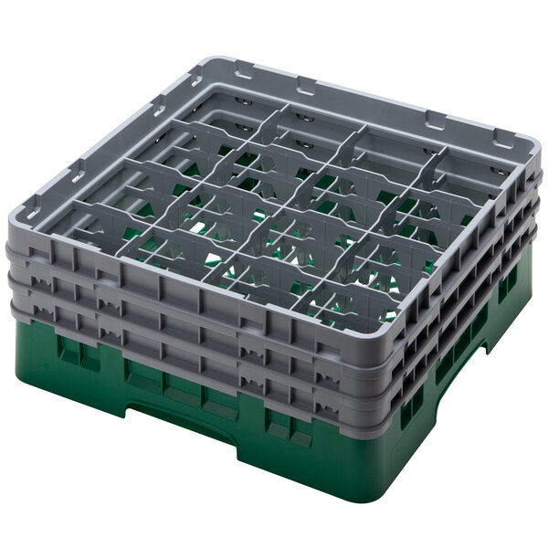 A green plastic Cambro glass rack with 16 compartments and 3 extenders.