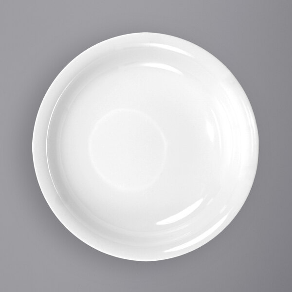 A close-up of an International Tableware white porcelain soup bowl with a rolled edge.