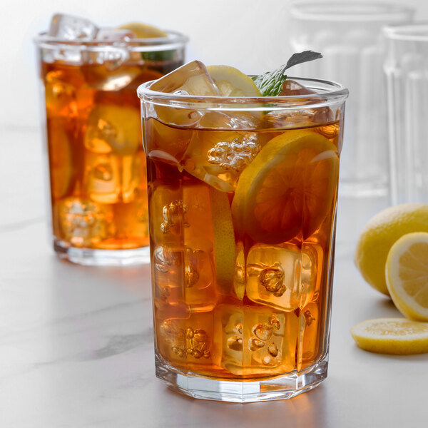 Two Arcoroc iced tea glasses with lemon slices on a white background.