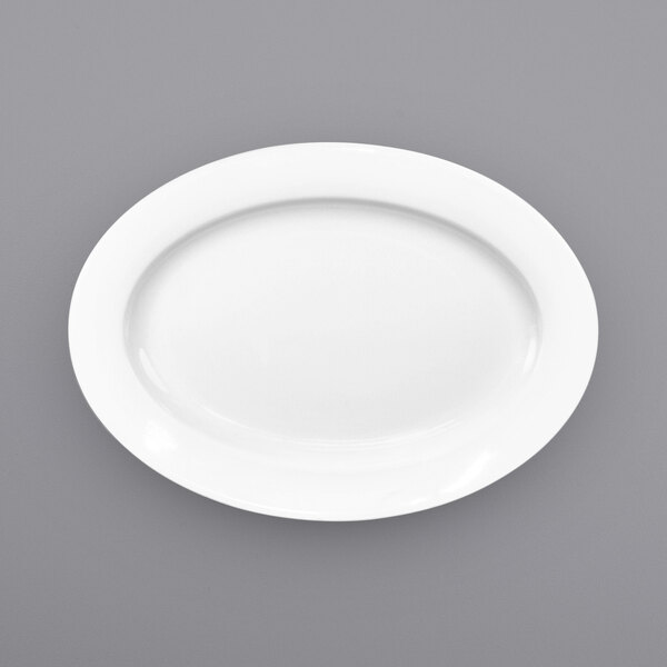 An International Tableware white porcelain platter with a wide rim on a gray surface.