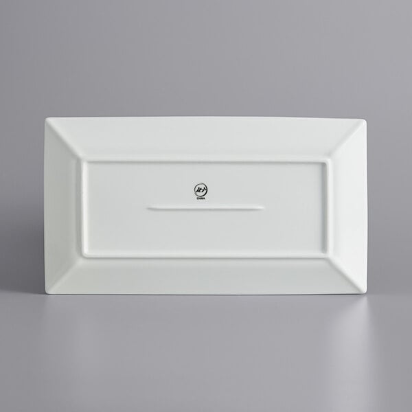 A white rectangular International Tableware porcelain platter with wide rim.