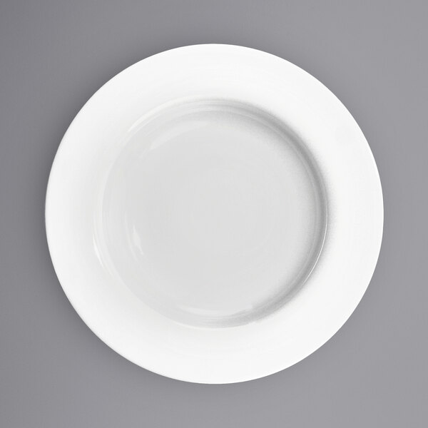 A close-up of a International Tableware Bristol bright white porcelain pasta bowl with a white rim.