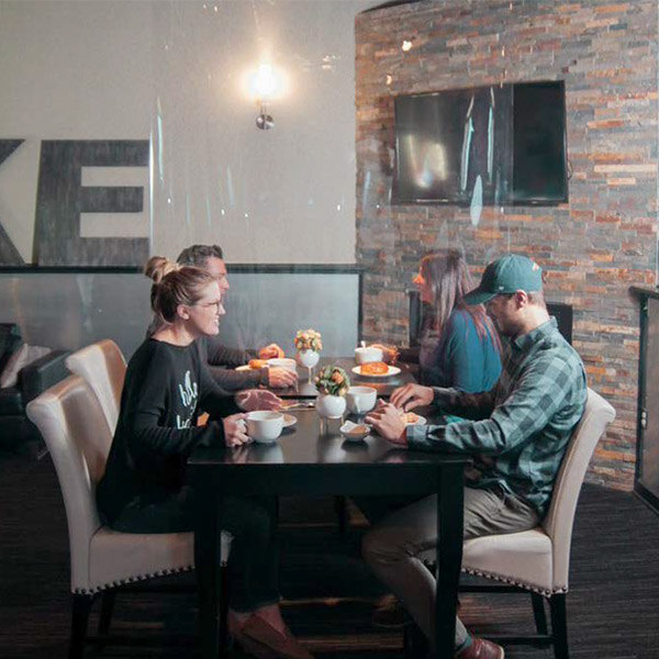 A room in a restaurant with American Metalcraft clear PVC partitions.