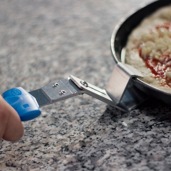 A person using a GI Metal stainless steel pan gripper to hold a pizza pan.