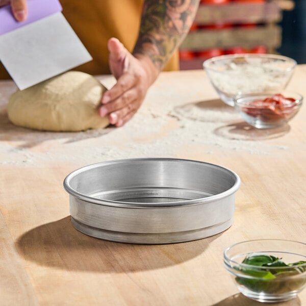An 8-inch by 2-inch heavy weight aluminum straight sided stackable cake or deep dish pizza pan.
