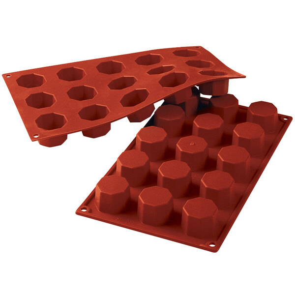 A red Silikomart silicone baking mold with 15 octagon cavities.