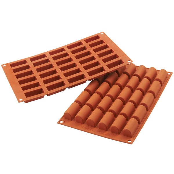 A close-up of a couple of orange Silikomart silicone baking molds.