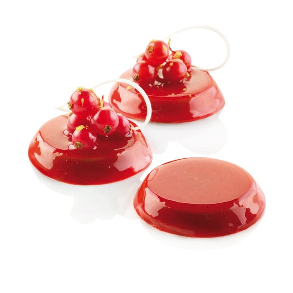Red round Silikomart Florentin desserts with berries on top.