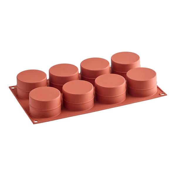 A red Silikomart silicone mold with cylindrical cavities.