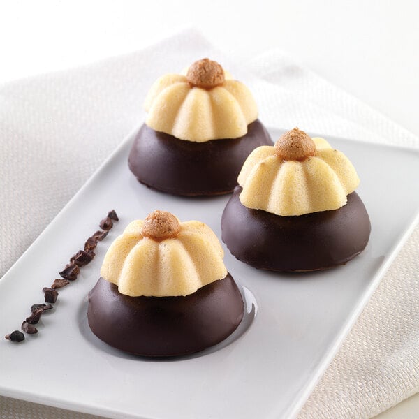 A white plate with three chocolate desserts made using a Silikomart mini Charlotte silicone baking mold.
