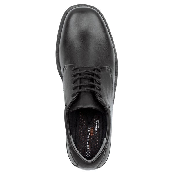 A close-up of a Rockport Works black leather oxford dress shoe with laces.