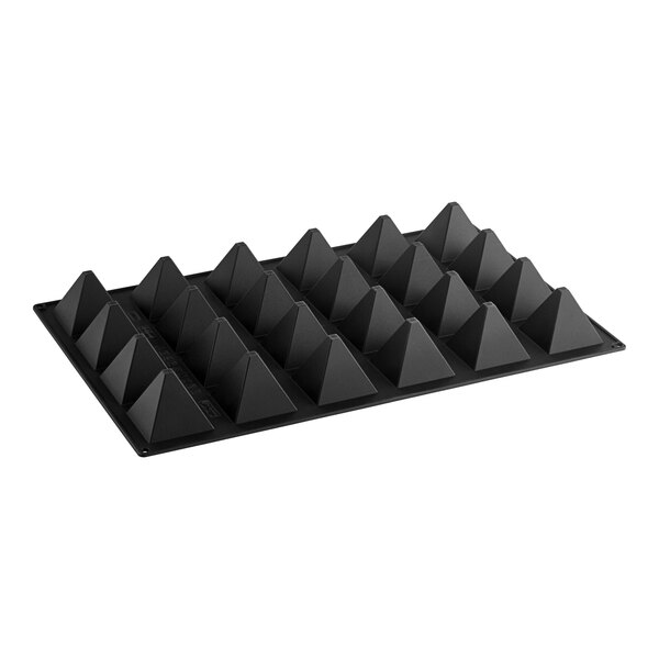 A black Silikomart pyramid shaped silicone baking mold on a white tray.