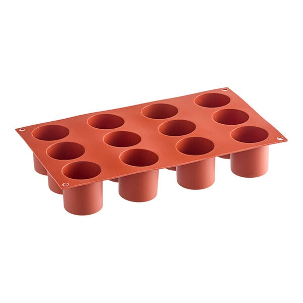 A red Silikomart silicone baking mold with 12 cylindrical cavities.