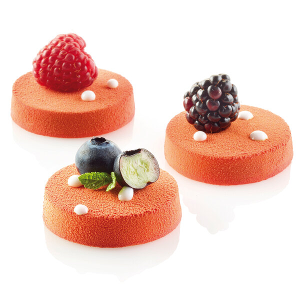 Three Silikomart Florentin cakes with berries on top of them.