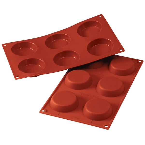 A red Silikomart silicone baking mold with six flan cavities.