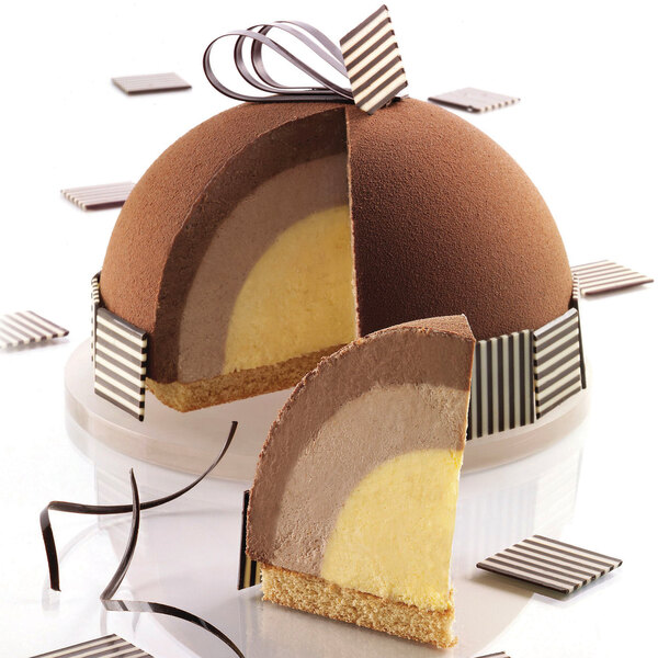 A square chocolate cake with a slice removed, showing layers of chocolate and vanilla.