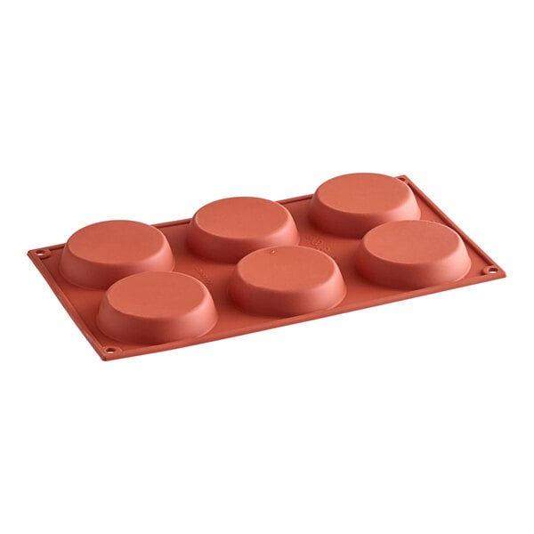 A red silicone baking mold with six circle cavities.