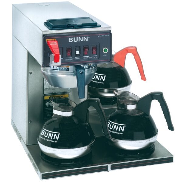 A Bunn commercial coffee brewer with three coffee pots under it.