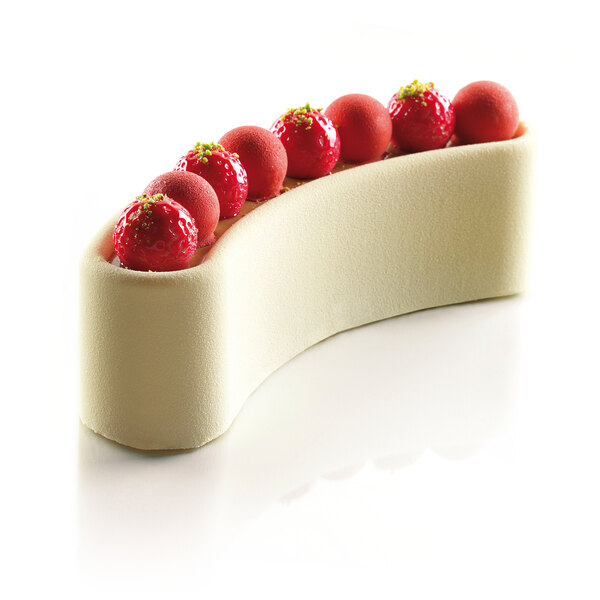 A white sponge cake with red strawberries on top baked in a Silikomart Stella Del Circo silicone mold.