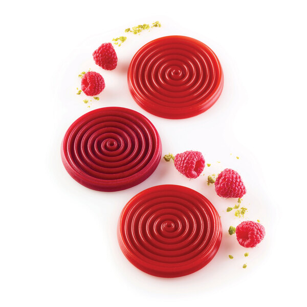 Red round desserts with raspberries in a Silikomart Tourbillon mold.