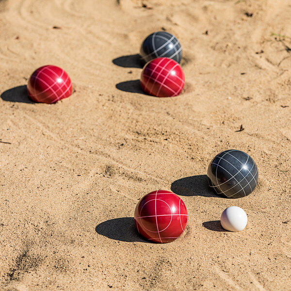 A group of Triumph resin bocce balls on the sand.