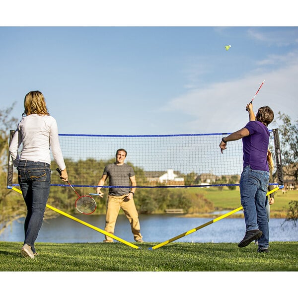 A group of people playing badminton on a Triumph Multi-Sport net set.