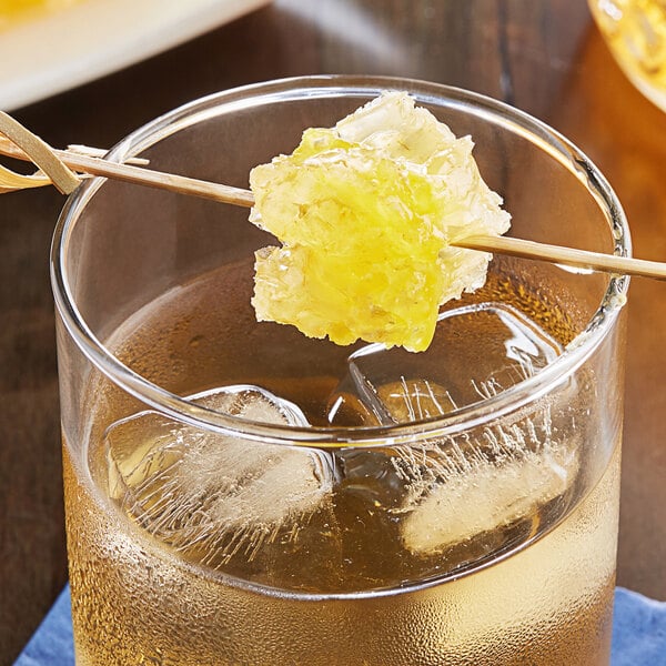 A glass of Monarch's Choice honeycomb with a drink on a counter.