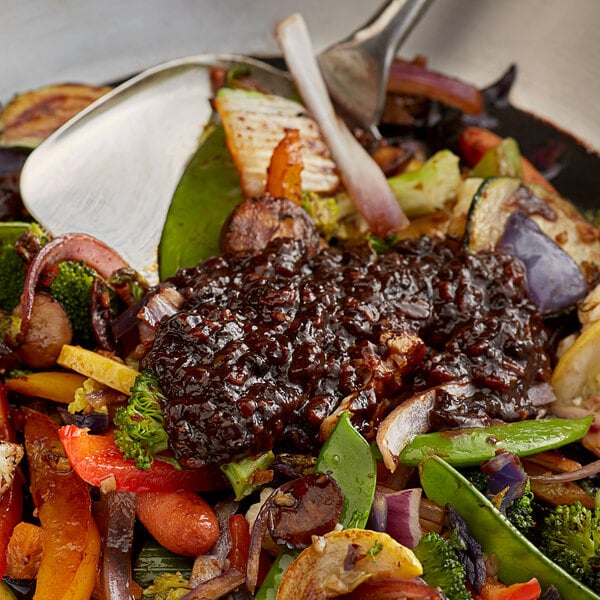 A bowl of food with Lee Kum Kee Black Bean Garlic Sauce on a table.